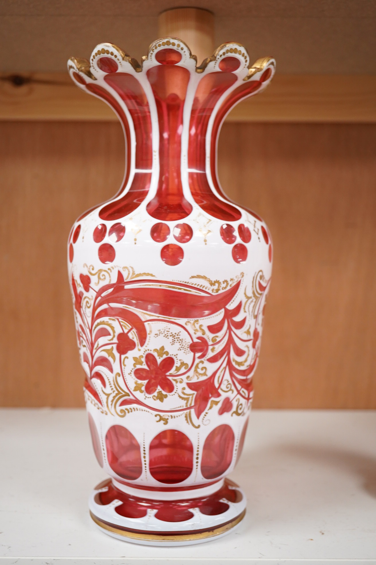 A 19th century Bohemian overlaid and gilt decorated cranberry glass vase, 29cm high. Condition - gilt decoration worn in places